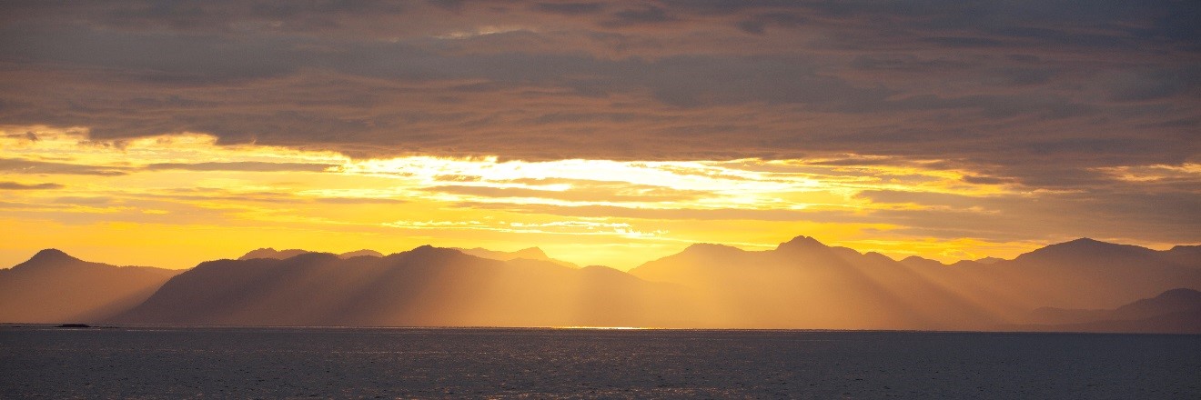 beautiful yellow sun rays coming down from the clouds in Glacier Bay, Alaska