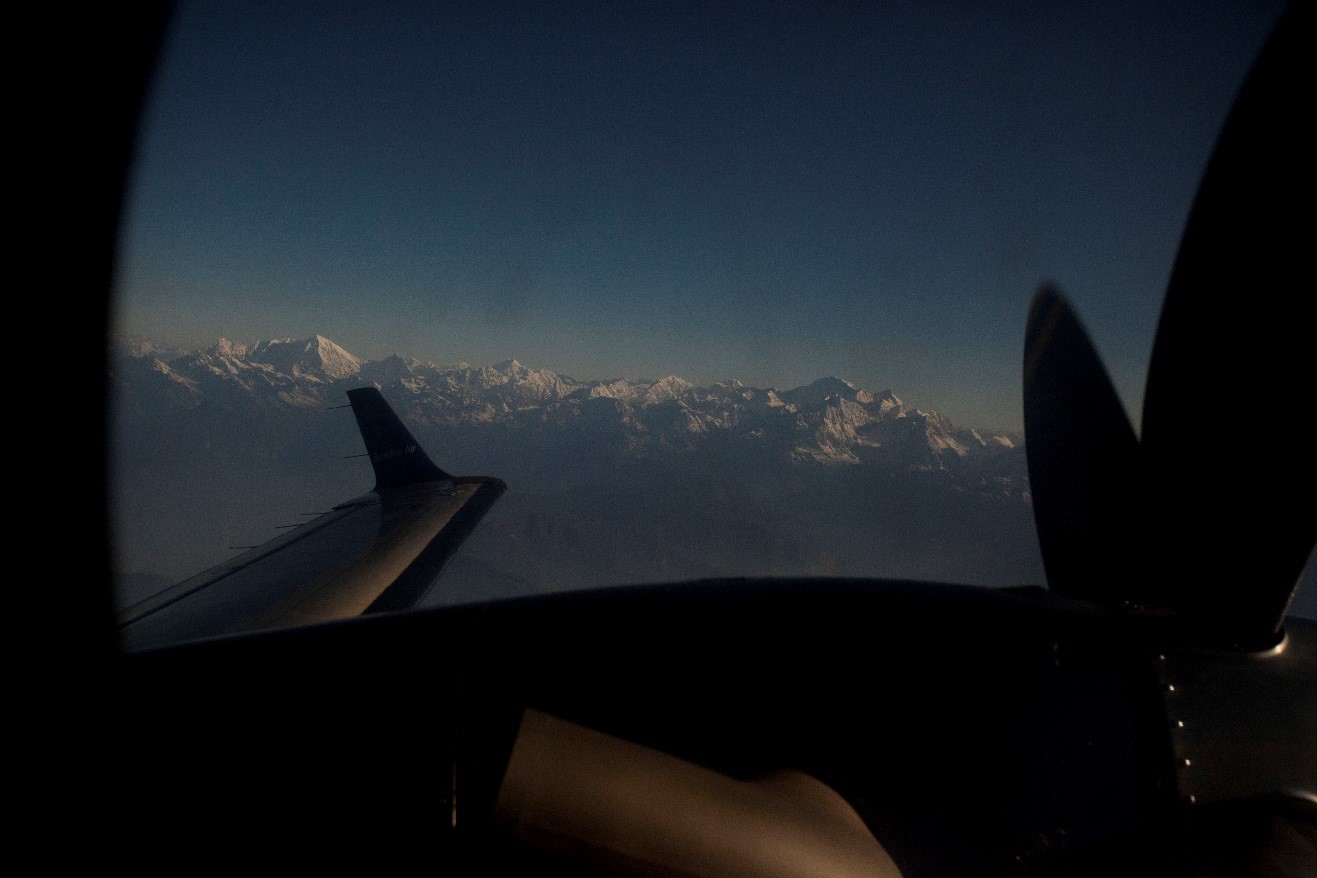 a view outside of the window while flying next to the himalayas