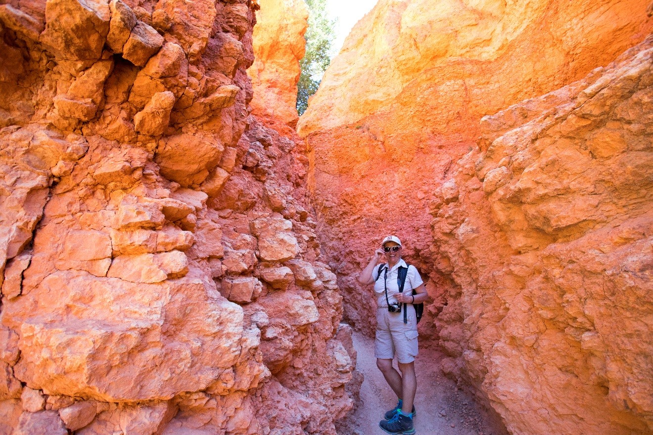 a colorful photo of a woman standing in a pathway with orange red and yellow rocks on either side