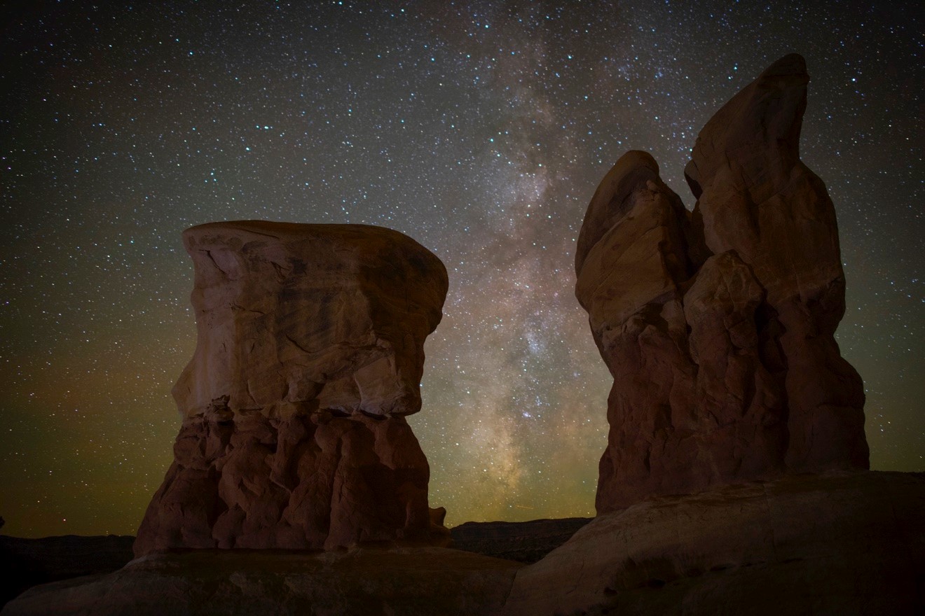 stone pillars frame an incredible view of the stars and milky way of Escalante National Monument