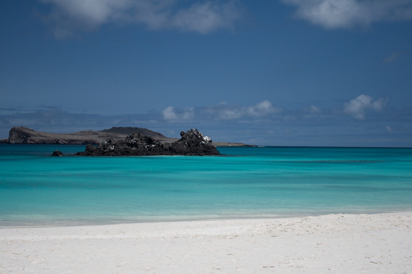 a beautiful photo of turquoise water and blue skies over gardner bay in Galapagos