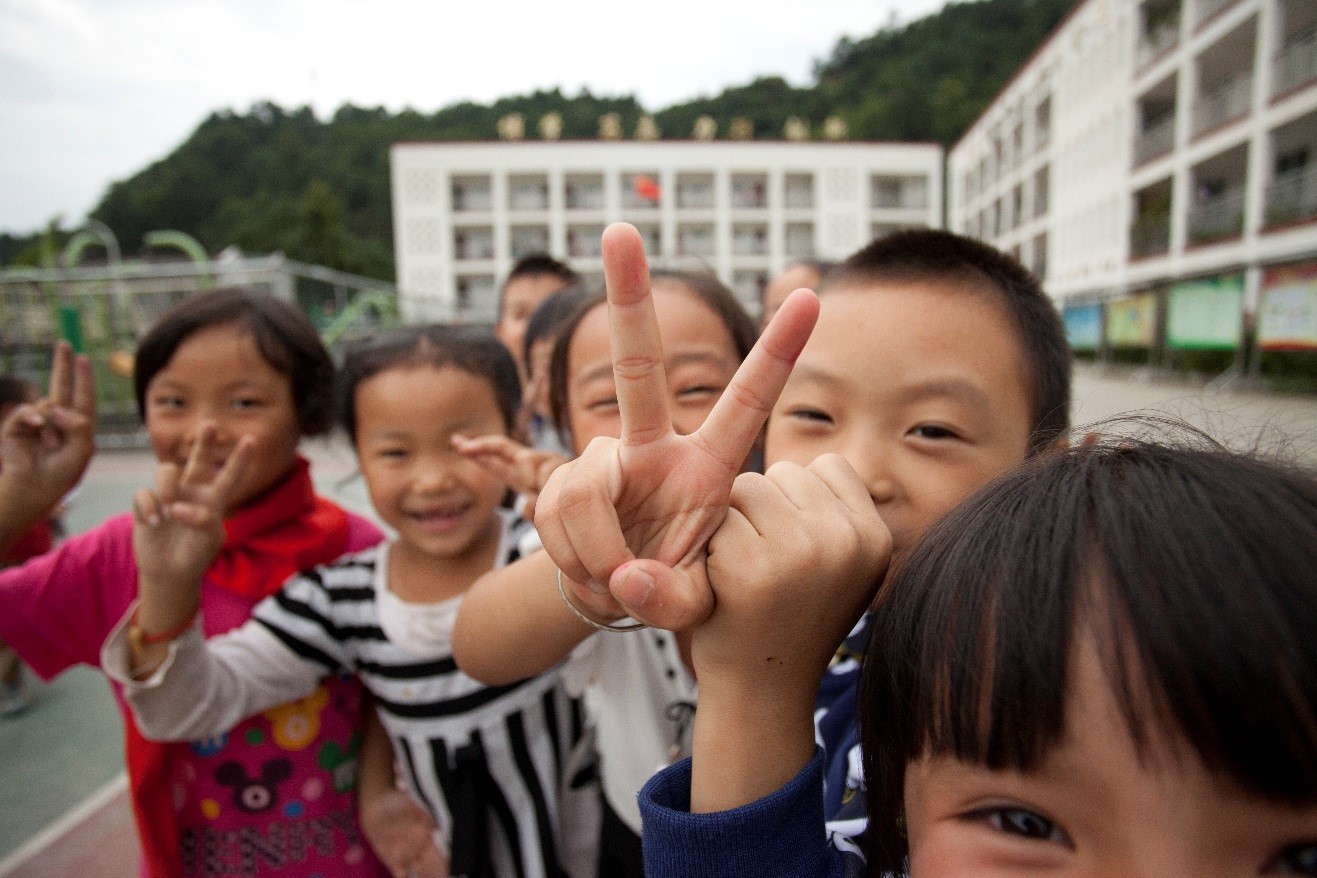 excited chinese children run up to me as a take a photo of them at their school