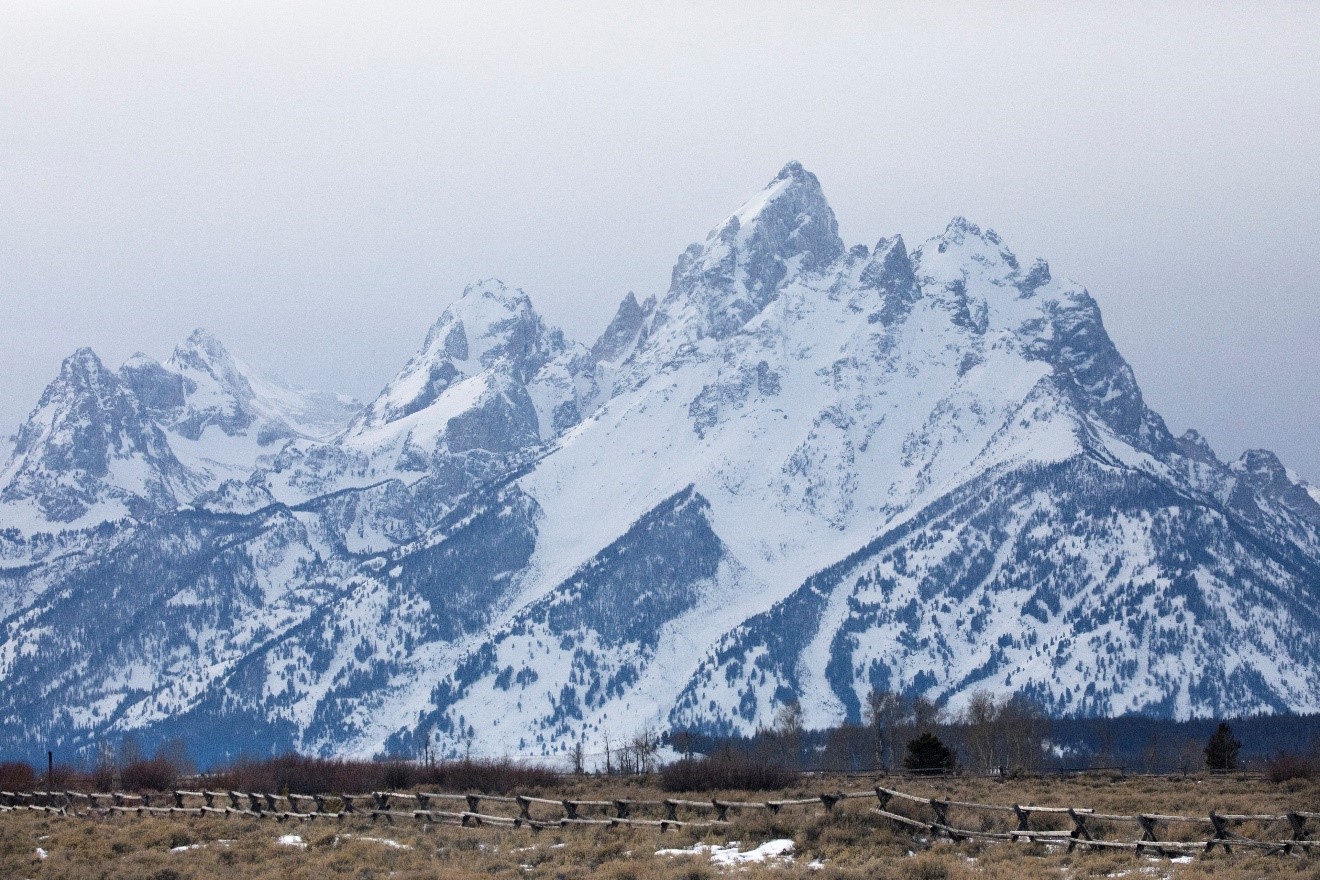 the grand teton sits mightily above the surrounding landscape