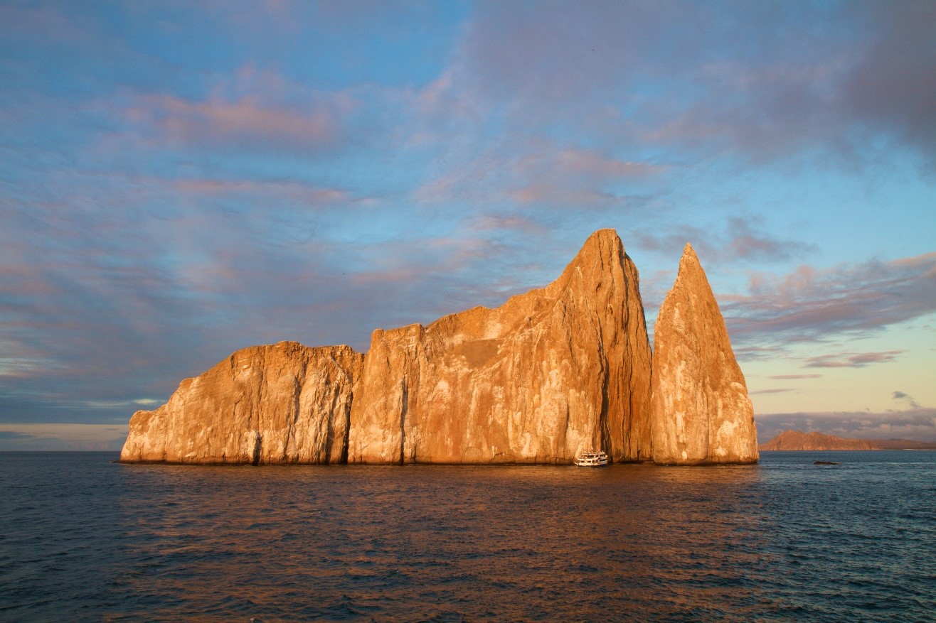 golden lighting illuminates kicker rock in the galapagos islands