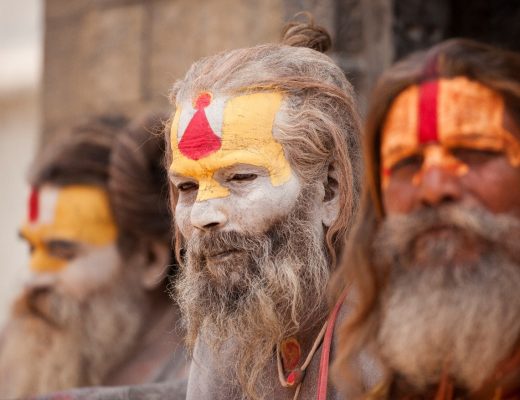 intriguing holi men with painted faces sit on the steps of a temple in kathmandu nepal