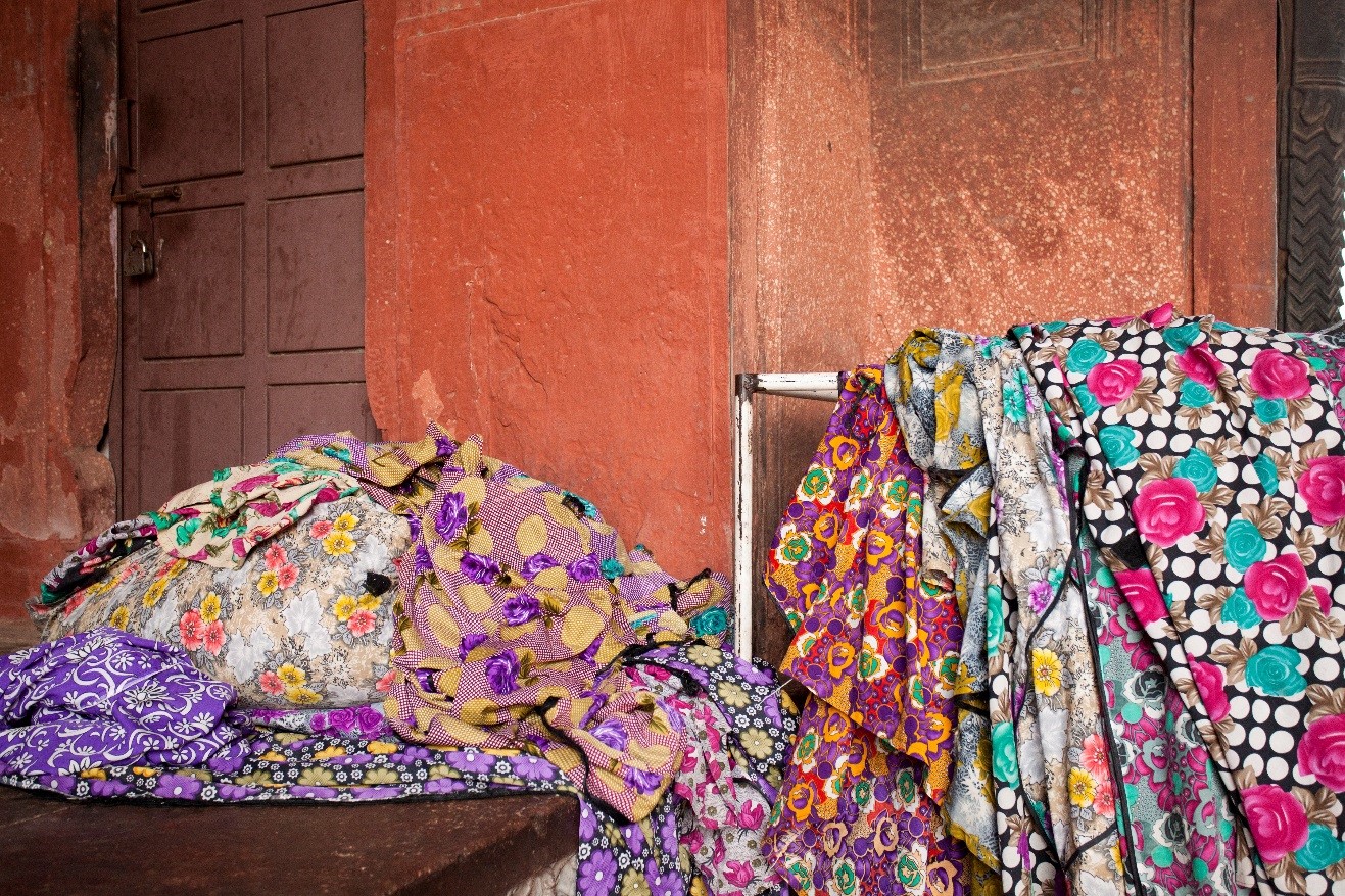 colorful fabrics lay around outside of a temple in India