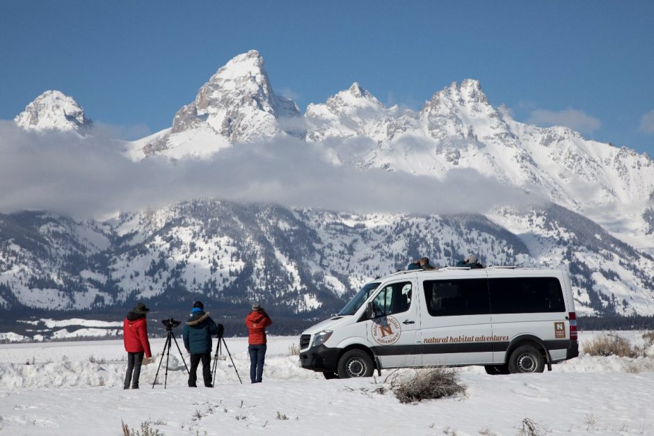 photographers and ecotourists look at the mighty grand teton range outside of jackson, wyomin