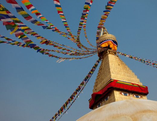 a stupa at a nepalese temple displays characteristic eyes and prayer flags
