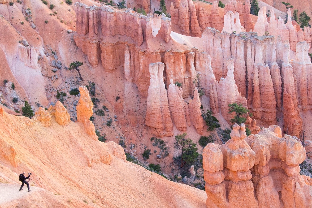 a photographer takes photos from below the rim in bryce canyon