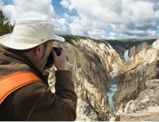 a man photographs the grand canyon of yellowstone falls