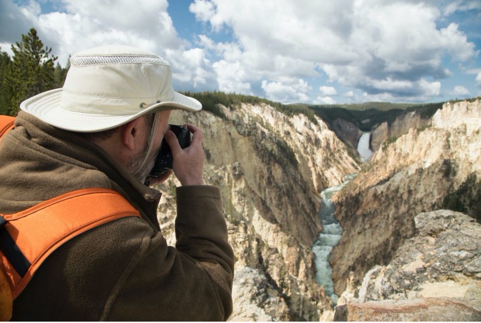a man photographs the grand canyon of yellowstone falls