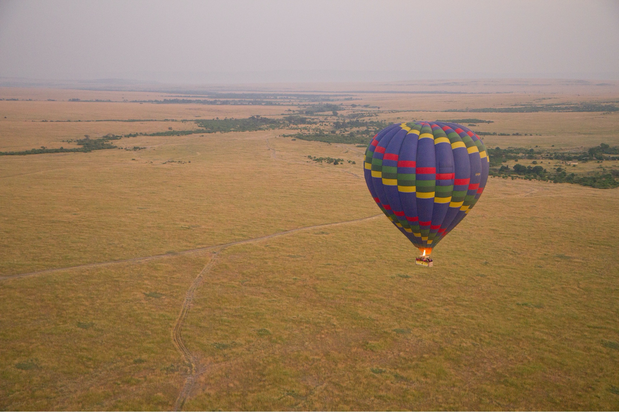 a single balloon floats over the Masai Mara