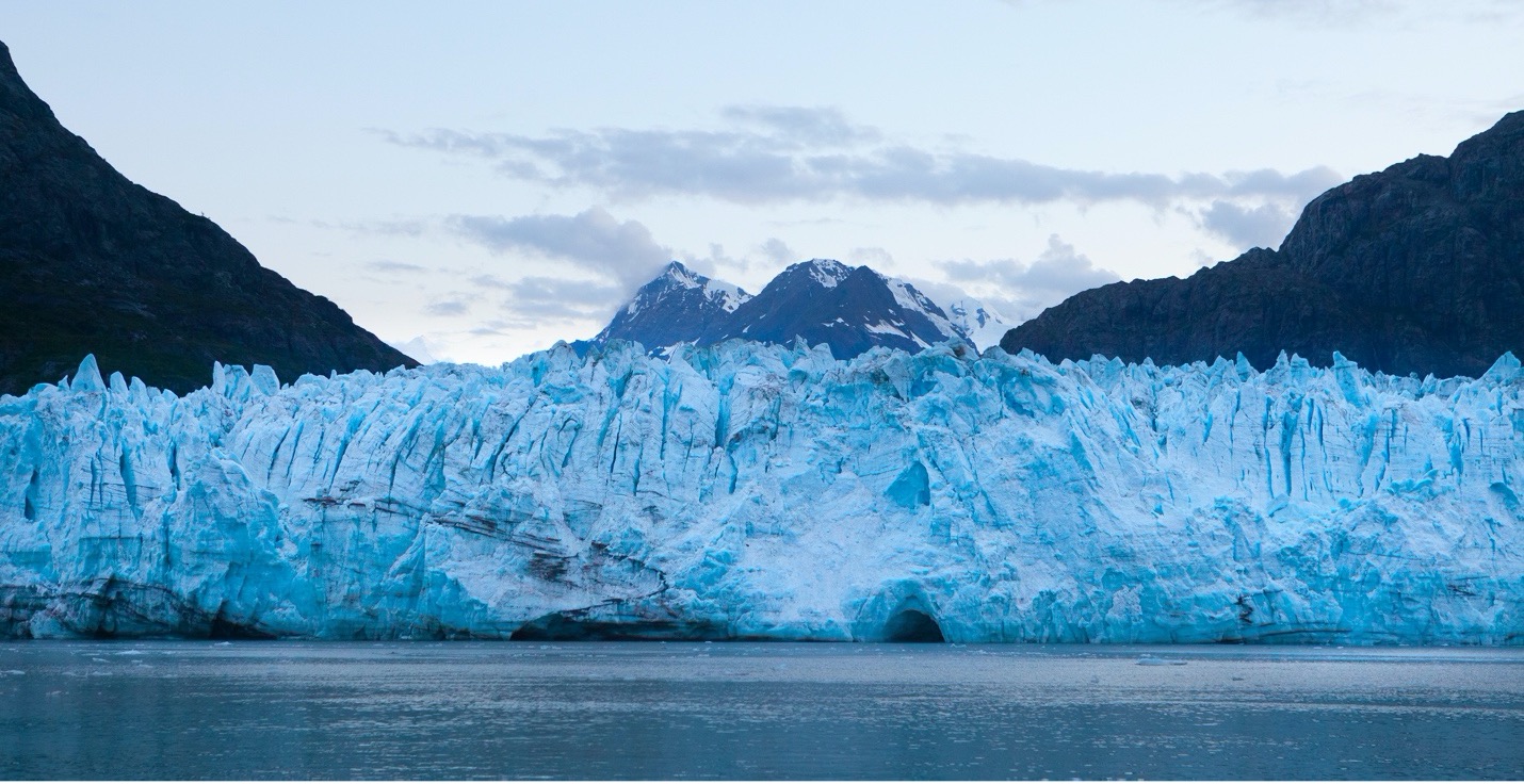a beautiful blue glacier spans edge to edge in the frame