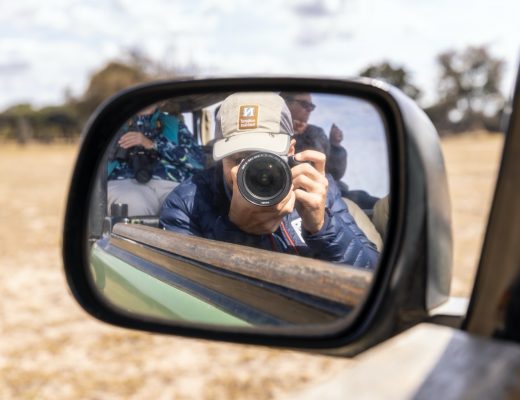 a photographer's self portrait in a rear view mirror