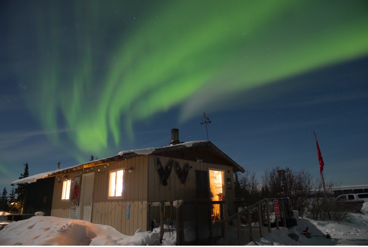 northern lights above a small cabin