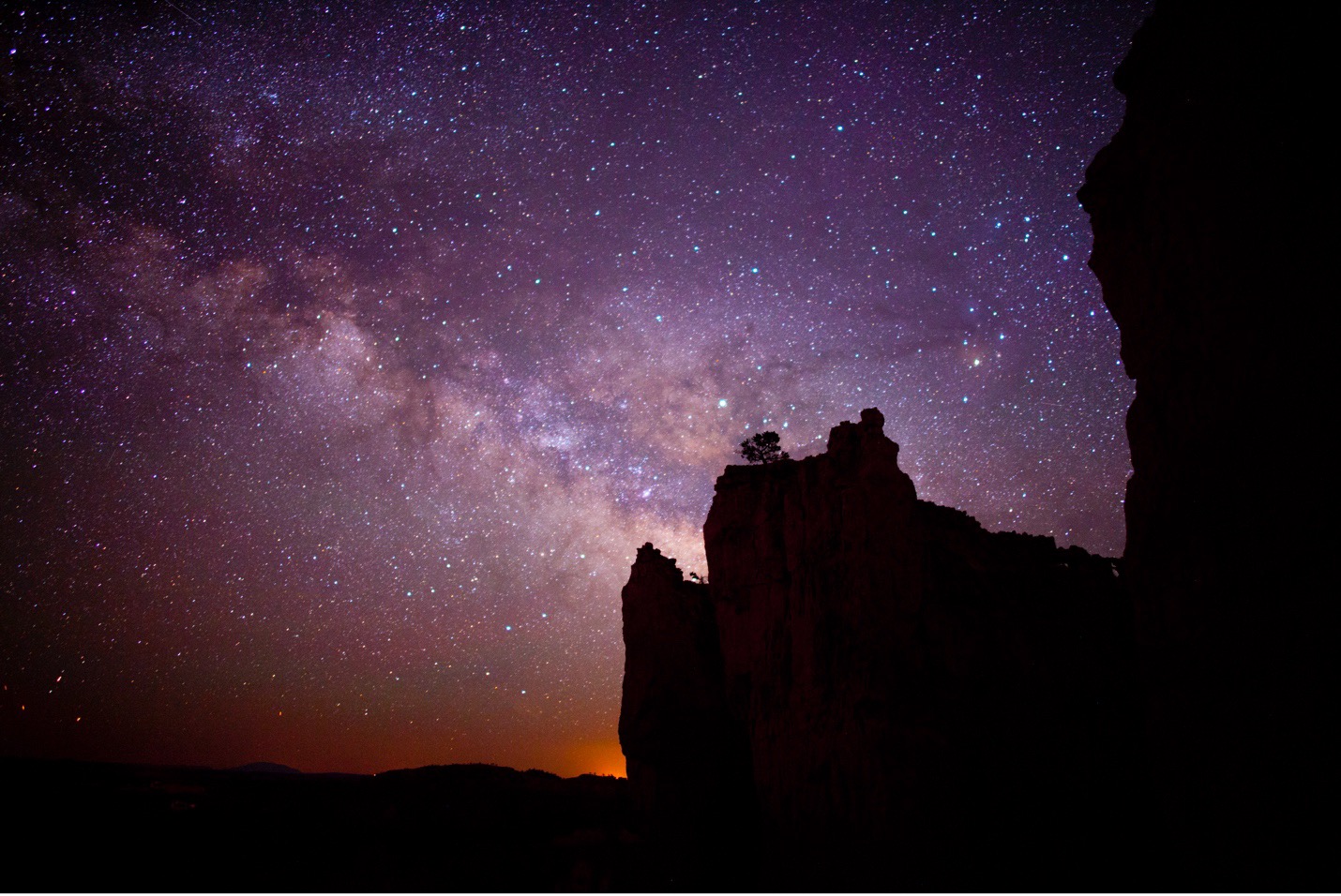 a silhouette of the cliffs of Bryce Canyon with milky way in the background